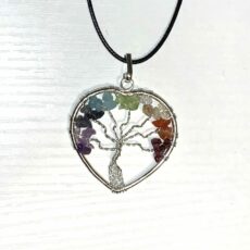 Pendentif 7 chakras sur cordon, de forme coeur avec à l'intérieur un arbre tressé d'une chaîne plaquée argent dont les branches mènent à un feuillage de pierres naturelles qui ensemble réunissent les 7 couleurs des chakras: violet, bleu foncé, bleu clair, vert, jaune, orange et rouge.