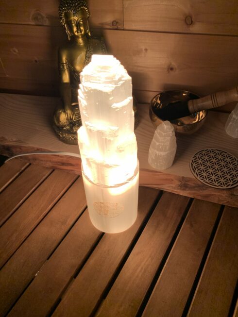 Lampe en pierre naturelle Sélénite. Couleur blanc translucide, en forme de montagne avec motif "Fleur de vie". Hauteur 30cm.