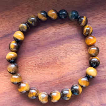 Bracelet en pierre naturelle Oeil de tigre, pierre variant d'une couleur noir au marron et au jaune. Ce minéral porte des vertus protectrices, qui évite d'être submergé par les émotions. Ce bracelet "Oeil de tigre" aide ainsi à combler le manque de confiance en soi.
