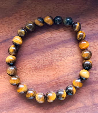 Bracelet en pierre naturelle Oeil de tigre, pierre variant d'une couleur noir au marron et au jaune. Ce minéral porte des vertus protectrices, qui évite d'être submergé par les émotions. Ce bracelet "Oeil de tigre" aide ainsi à combler le manque de confiance en soi.