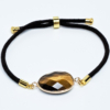 Bracelet œil-de-tigre, composé d'une seule pierre naturelle taillée, mesurant environ 2cm. Bracelet en cordon réglable noir.